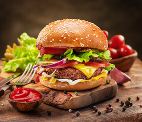Tasty cheeseburger on wooden tray, spices and vegetables near it.