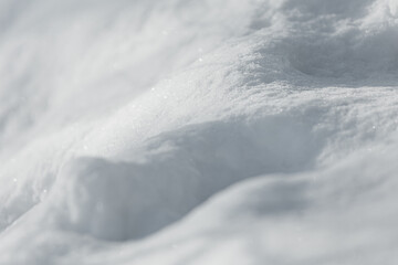 Photo of snow  cover with shadows on it under warm sunlight on the winter, some  snowflakes is shining on a sun. Wintertime atmosphere with white snow.
