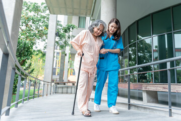 Asian woman doctor shook hands, encouraged and supported elderly woman patient, Which holds a cane for help support to walking. to  health insurance and osteoarthritis concept.