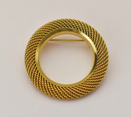 Old gold vintage brooch on beige background, accent retro jewelry for women