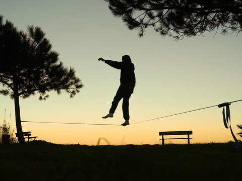 Silhouette of man on a slackline, equilibrium sport, slacklining activity