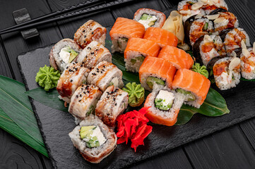 Big set of Asian food. Sushi and rolls on a dark background.