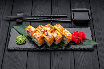 Traditional delicious fresh sushi roll set on a black background . Sushi roll with rice, cream cheese, salmon.