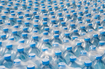 Fototapeta premium Rows of stacked plastic water bottles, Packaging of products piled in the factory area to prepare for sale