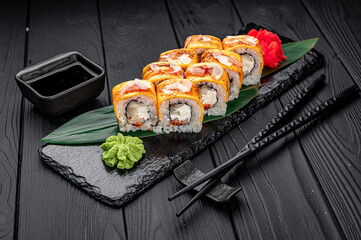 Traditional delicious fresh sushi roll set on a black background . Sushi roll with rice, cream cheese, salmon.