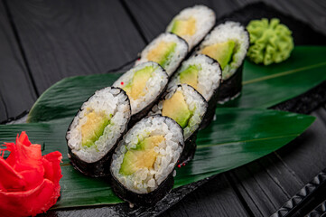 Appetizing sushi maki roll on a black stone plate