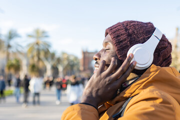 Close-up of a happy man listening to music in the city.