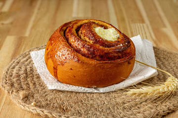Bun with cream on a wooden table.
