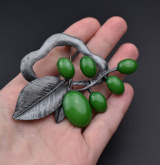 Vintage brooch on a woman's hand, old retro jewelry