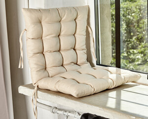 Cozy window seat with soft beige fabric cushion
