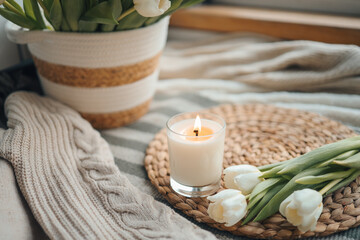Burning candle and tulips in home interior