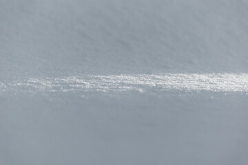Photo of sunlight on the snow  cover under warm sunlight on the winter, some  snowflakes is shining on a sun. Wintertime atmosphere with white snow.