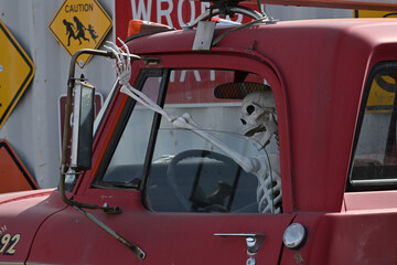 Skeleton behind steering wheel of old pickup.