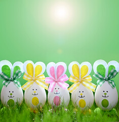 Funny easter eggs in the grass on green background. Easter background. Happy Easter.