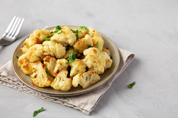 Homemade Roasted White Cauliflower on a Plate, side view. Space for text.