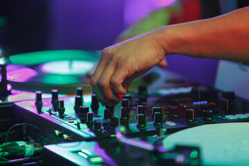 Hip hop dj mixing music with sound mixer and turntables. Club disc jockey playing musical set on stage
