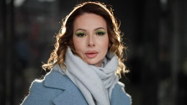 A delightful middle-aged beauty with makeup in outerwear indoors with a contour light portrait
