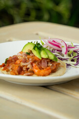 Delicioso taco de camarón con queso y aguacate en restaurante de mariscos