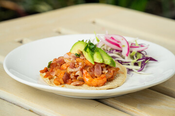 Delicioso taco de camarón con queso y aguacate en restaurante de mariscos