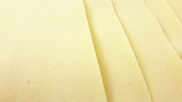 Yellow lasagna pasta dough sheets circle rotation close up