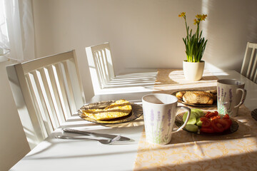 Breakfast on a fork on a white table in the morning sun in the kitchen.