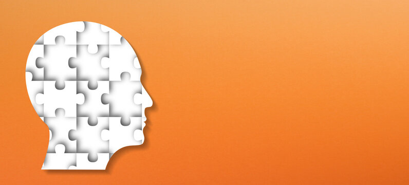 Head made of white jigsaw puzzle on orange background - Powered by Adobe