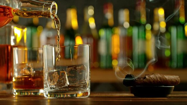 Detail of whisky bottle, pouring shot into glass, super slow motion. Filmed on high speed cinema camera, 1000fps.