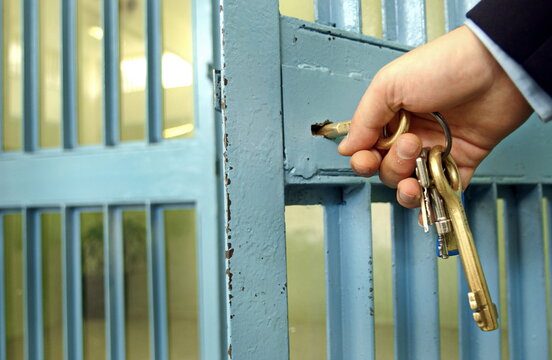 Police officers close the door in the prison corridor.