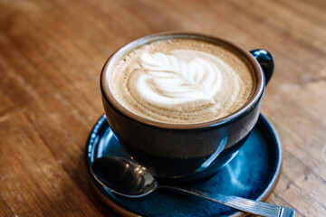 A cup of cappuccino coffee on a table in a cafe. Coffee hot drink in a ceramic cup for breakfast in the morning.