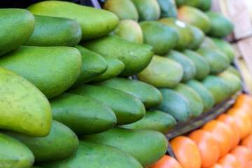 Ripe green mangoes at the fruit market. Harvest of exotic sweet mangoes and fruits.