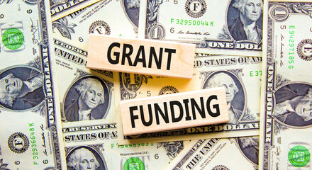 Grant funding symbol. Concept words Grant funding on wooden blocks. Beautiful background from...