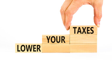 Lower your taxes symbol. Concept words Lower your taxes on wooden blocks on a beautiful white table...