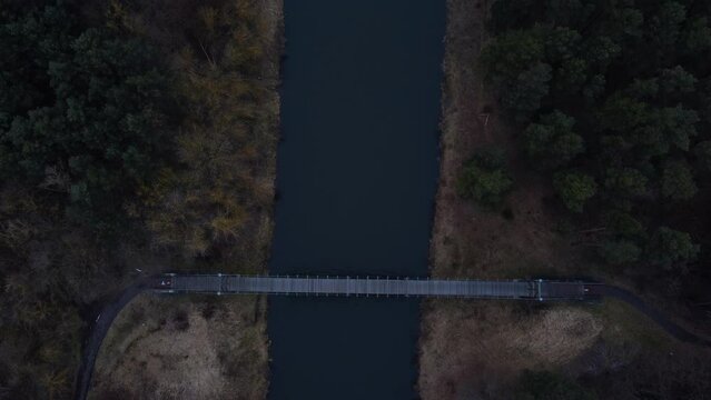 Field, lake and bridge from a bird's-eye view. Beautiful autumn. Drone video. Autumn forest and blue lake. Black river. Blue water. Autumn landscape. Gray fields. 