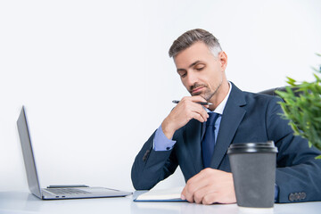 mature boss writing at the table in business office