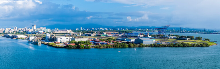 Naklejka na ściany i meble A panorama view from the port towards the commercial dock amd airport of San Juan, Puerto Rico on a bright sunny day