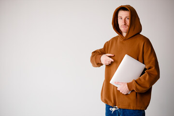 Young programmer sitting at the desk in his office and working .He talk with someone and smiling.