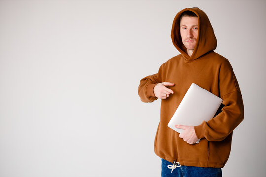 Young programmer sitting at the desk in his office and working .He talk with someone and smiling.