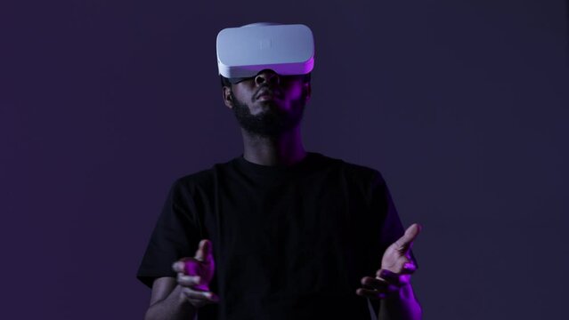 African American guy in Smart glasses of virtual reality. Augmented reality game, future technology, AI concept. VR. Neon light.