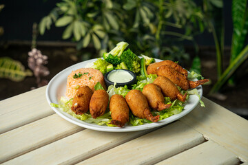 camarones empanizados con relleno ensalada y acompañado de arroz en restaurante de mariscos
