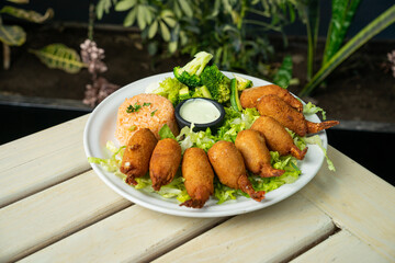 camarones empanizados con relleno ensalada y acompañado de arroz en restaurante de mariscos