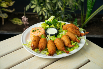 camarones empanizados con relleno ensalada y acompañado de arroz en restaurante de mariscos