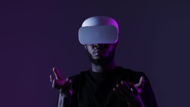 African American guy in Smart glasses of virtual reality. Augmented reality game, future technology, AI concept. VR. Neon light.