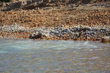 Formation of salty rocks in the Dead Sea, Jordan with the Dead Sea muds on a bright sunny day.