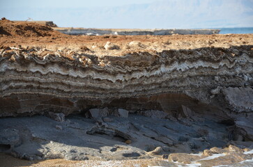 Formation of salty rocks in the Dead Sea, Jordan with the Dead Sea muds on a bright sunny day.
