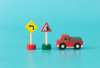 Wood sings: construction truck with traffic signs on blue background isolated. Symbols: wood toy for kids.