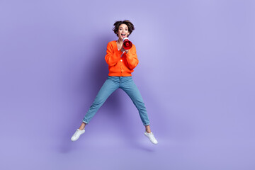 Fototapeta na wymiar Full body size photo of carefree activist funky girl jumping hold loudspeaker megaphone screaming phrase protest isolated on violet color background