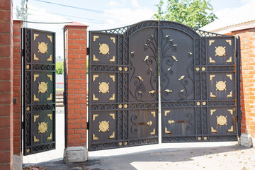 Cast iron gates and wicket with brick pillars