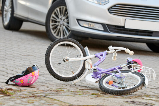 child bicycling helmet and bicycle near car during collision accident in the city