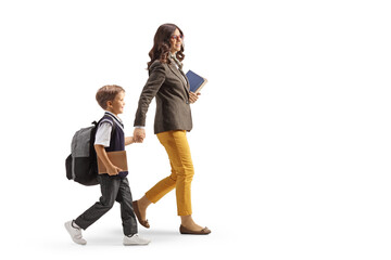 Full length profile shot of a teacher and a schoolboy walking and holding hands