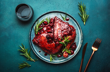 Baked duck legs in cherry and red wine sauce with rosemary. Delicacy dinner. Blue table background,...